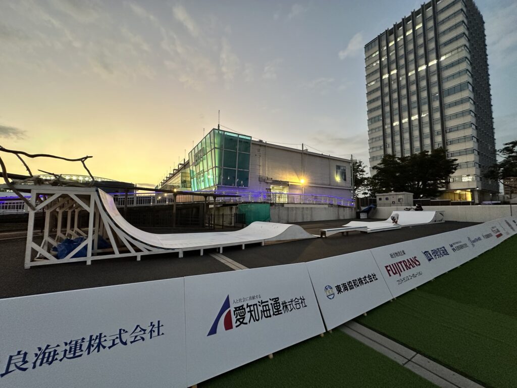 アーバンスポーツパーク全景(夕景)。手前からH1800クォーターパイプ、ビッグウェーブ、奥にグラインドボックスとH1000クォーターパイプ。右手前はスポンサーボード